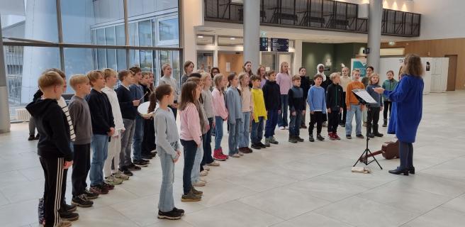 Barnkören uppträder i sjukhusets aula.