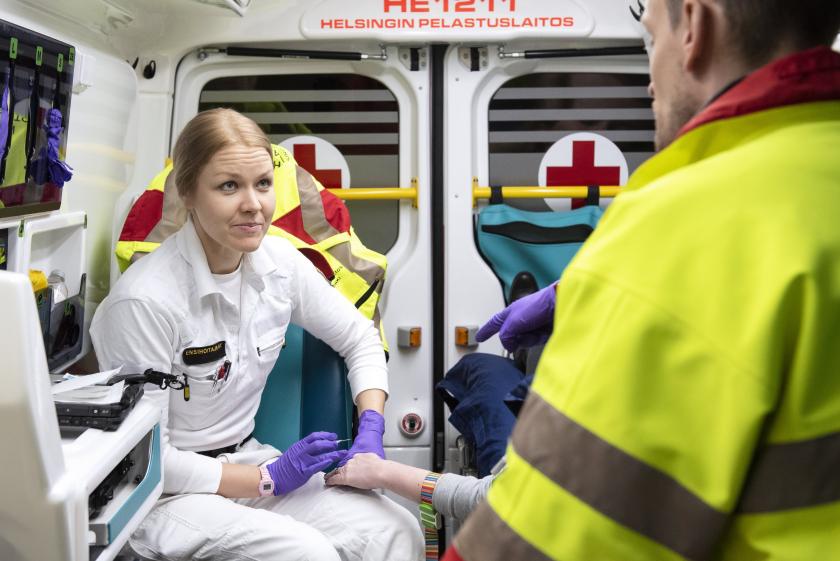 Ensihoitaja, potilas ja lääkäri ambulanssissa