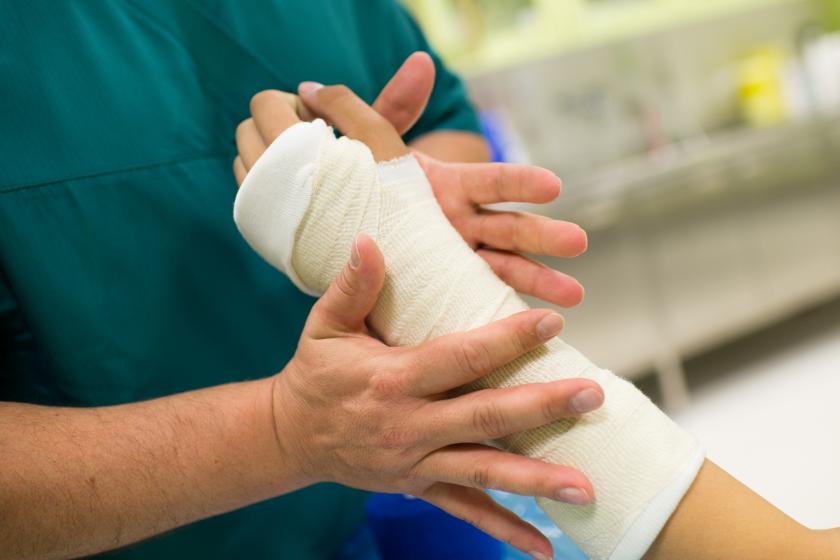 Sairaanhoitaja kipsaa potilaan käden