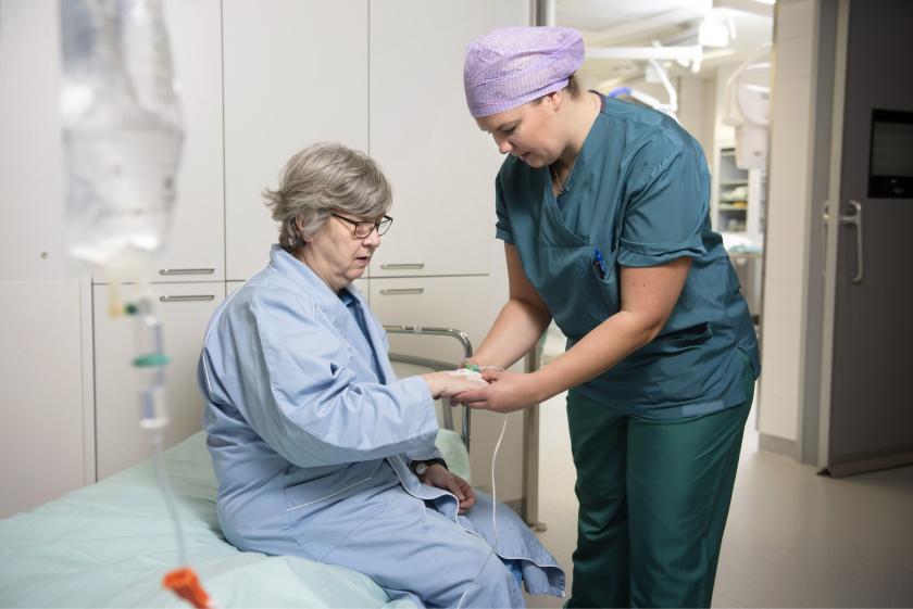 Kuvituskuva: Leikkaushoitaja valmistelee potilasta leikkaukseen