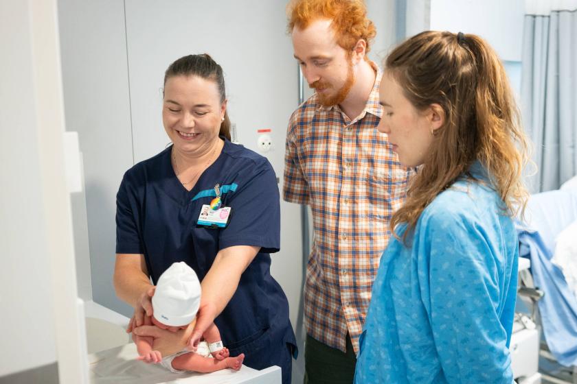 Kätilö Mari Nygren opastaa perhettä vauvan hoidossa