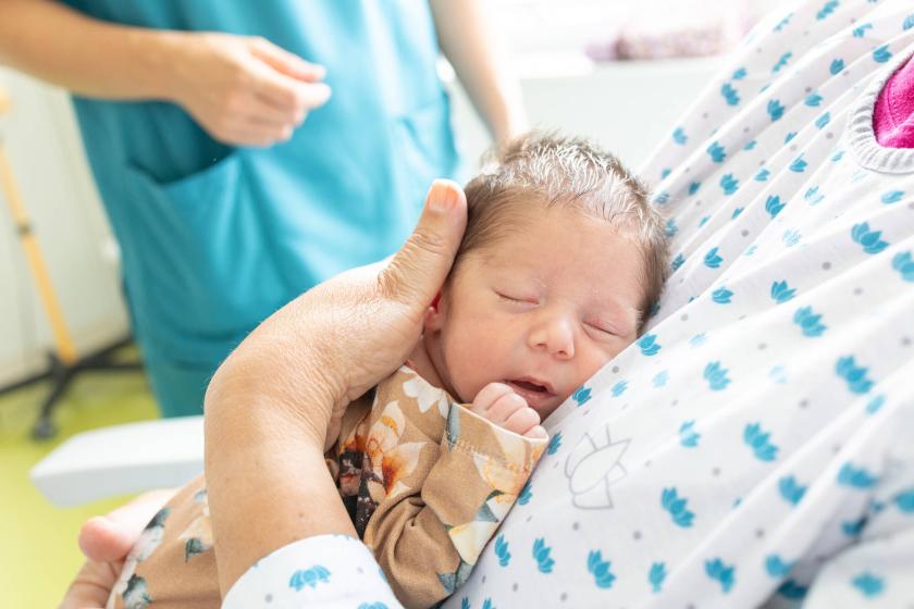 Vauva vapaaehtoisen perhekaverin sylissä