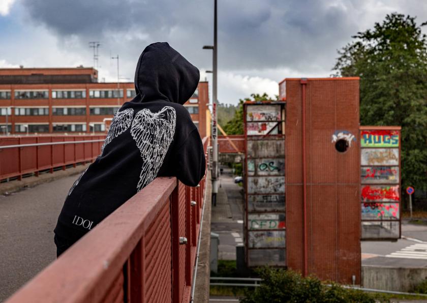 Kuvituskuva: nuori katselee sillalta ränsistynyttä lähiötä