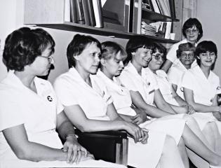 Sairaanhoitajia ja apuhoitajia valkoisissa suoja-asuissa.