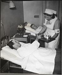 Apusisar tarjoilee ruokaa potilaalle.