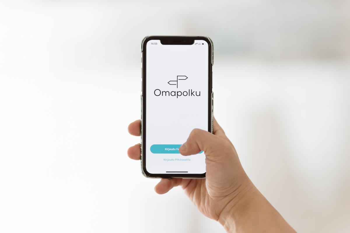 Käsi selaa kännykästä Omapolun etusivua.