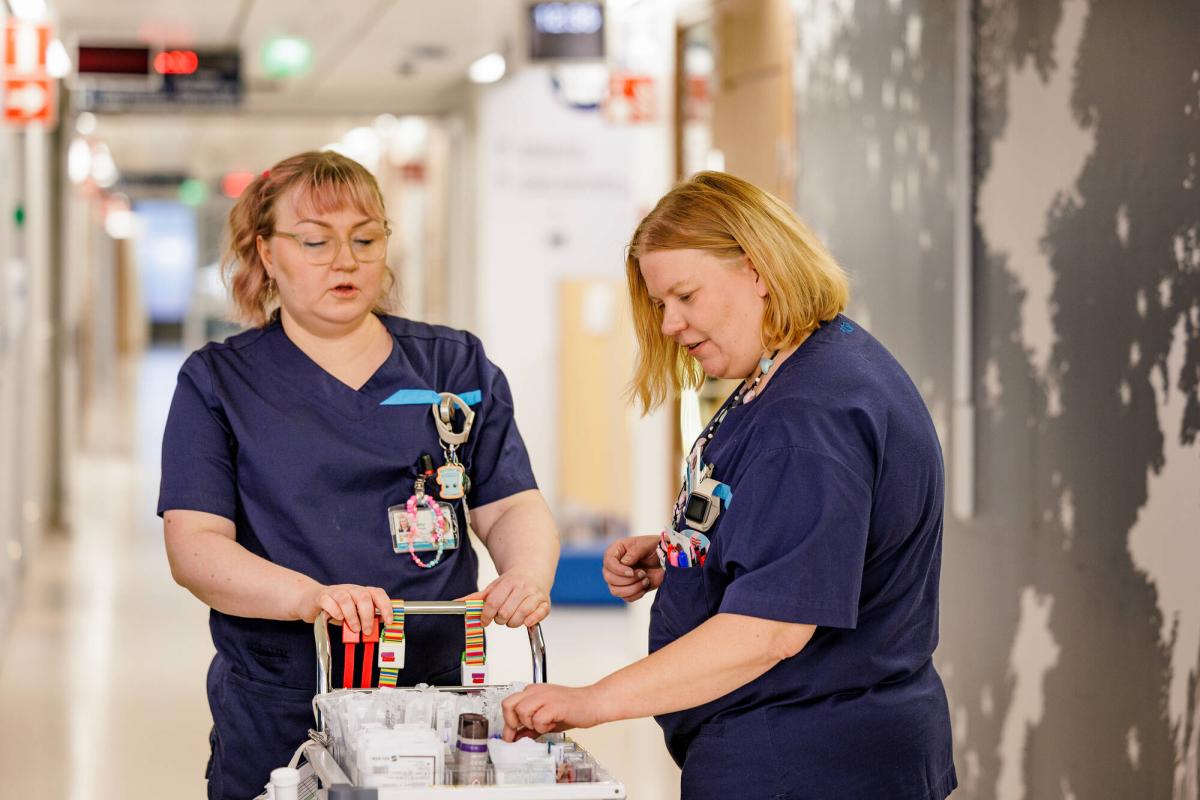 Kaksi hoitajaa sairaalan käytävällä.