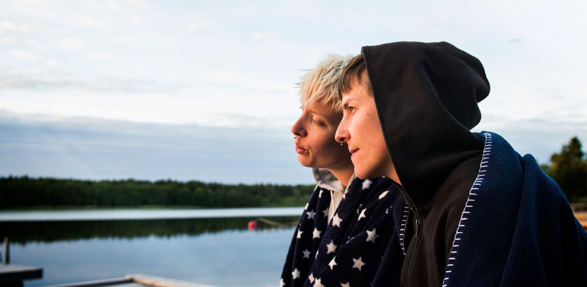 Kaksi nuorta järven rannalla.