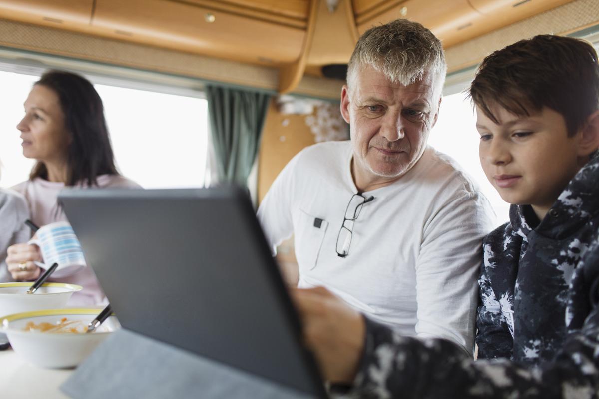 Ett barn och en vuxen ser på en bärbar dator.