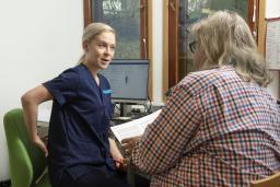 Sairaanhoitaja keskustelee potilaan kanssa.