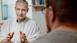 Lääkärimies ja potilas selin.