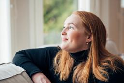 Iida Åfeldt hymyilee ja katsoo ikkunasta ulos.