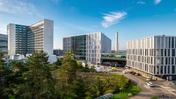 Meilahden sairaala-alueen sairaalat, etualalla puita ja pensaita.