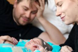 Vanhemmat katselevat nukkuvaa vastasyntynyttä.