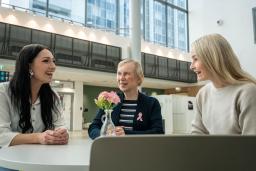 Kolme naista keskustelee pöydän ääressä
