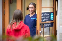 Seri-tukikeskuksen työtekijä vastassa asiakasta ovella.