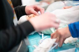 Lähikuva käsistä, jotka kokeilevat vauvanukella tehdä erilaisia demoja.